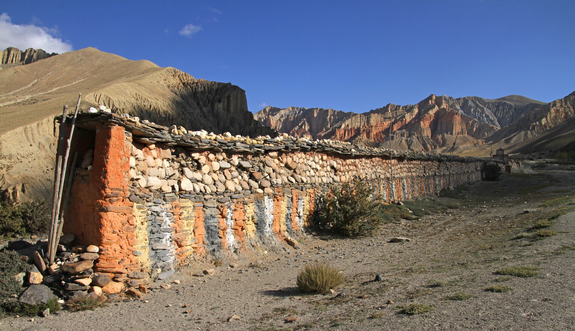 The mani stone wall protecting the intestines and the blood splatters on the red mountains behind